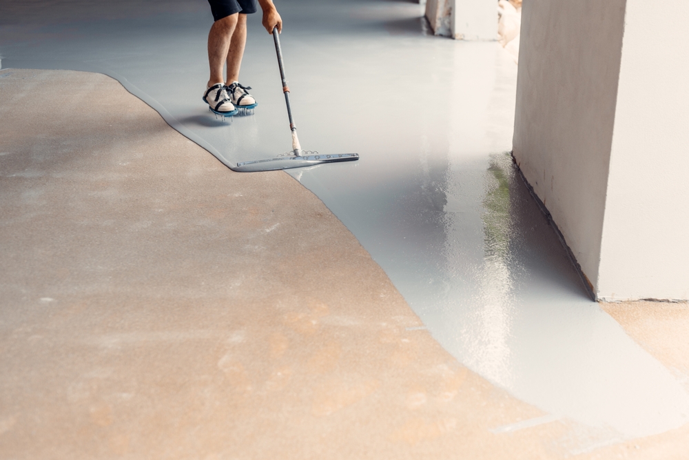 Is Epoxy Flooring Right for My Business? 1 Epoxy floor installation over existing concrete using roller and rubber spatula