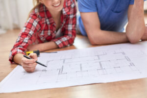 Home 13 repair, building, renovation and people concept - close up of happy couple looking at blueprint at home