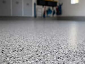 Indoor photo of garage epoxy floor, grey and white and black speckle, at an angle
